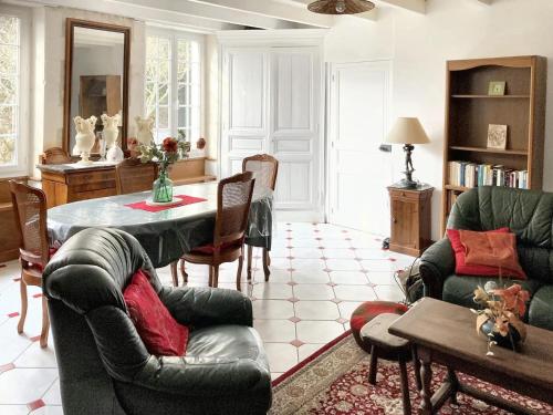 un salon avec une table et des chaises dans l'établissement Maison confortable au cœur de Fleurac avec grand jardin, à Fleurac