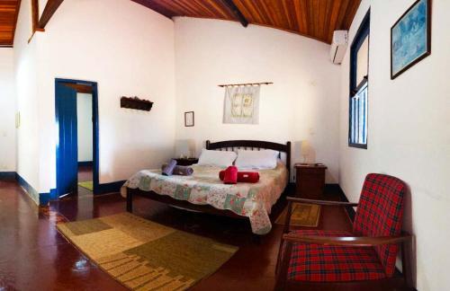 a bedroom with a bed and a chair in a room at Hotel Fazenda Primavera da Serra in Brotas