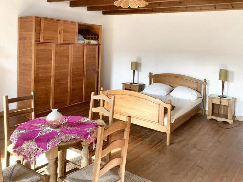 1 dormitorio con 1 cama, mesa y sillas en Maison de 3 chambres avec jardin clos et wifi a Fleurac, en Fleurac
