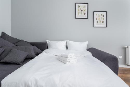 - un lit blanc dans le salon doté d'un canapé dans l'établissement Osiedle Avia Modern Apartment, à Cracovie
