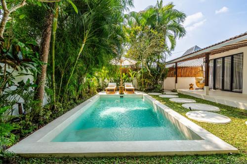 a swimming pool in the backyard of a villa at Berapi Villa by EVDEkimi - Elegant 3BR Ubud Home with Pool & Kitchen near Central Ubud in Ubud