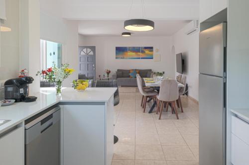 a kitchen and living room with a table and chairs at Villa YOLO in Peyia