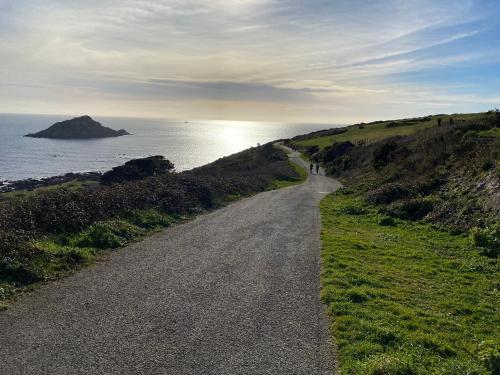 a dirt road next to the ocean on a hill at The Ivy Barn Holbeton in Plymouth