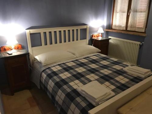 Colle San LorenzoにあるAntico Casale San Lorenzoのベッドルーム1室(大型ベッド1台、ナイトスタンド2台付)