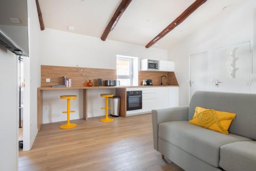 un salon avec un canapé et une cuisine dans l'établissement Pin * Spacieux * Linge hôtelier * Fibre * Confort, à La Destrousse