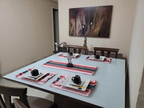 a white table with chairs and plates on it at Apartamento Farolandia in Aracaju