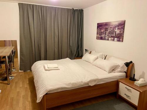 a bedroom with a bed with white sheets and a window at Spacious 1BR Apartment with Balcony above Citygate Shopping Complex with Metro Access in Vienna