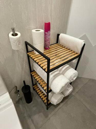 a towel rack with towels and toilet paper in a bathroom at Boogalow Hostel in Gijón