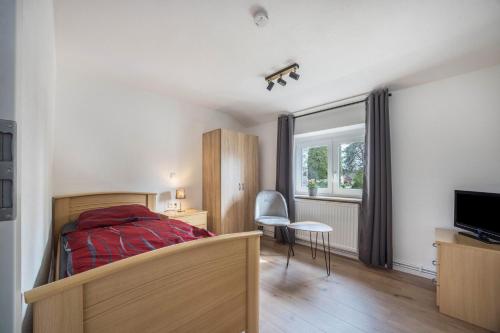 Schlafzimmer mit einem Bett, einem Schreibtisch und einem TV in der Unterkunft Ferienhaus Inge in Oldenburg