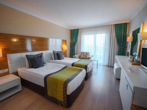 a hotel room with two beds and a couch at Asteria Family Resort Belek in Belek