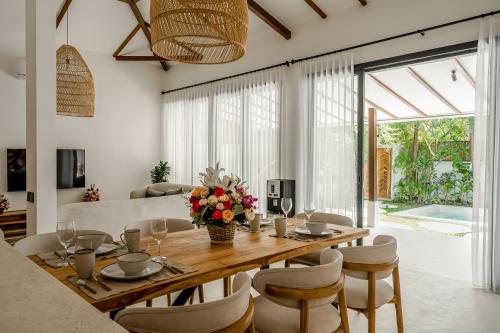 a dining room with a wooden table and chairs at Berapi Villa by EVDEkimi - Spacious 3BR Villa with Pool & Kitchen close to Ubud Attractions in Ubud