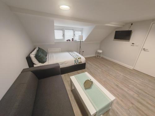a room with a bed and a couch and a table at Slieve Apartment Suites in Birmingham
