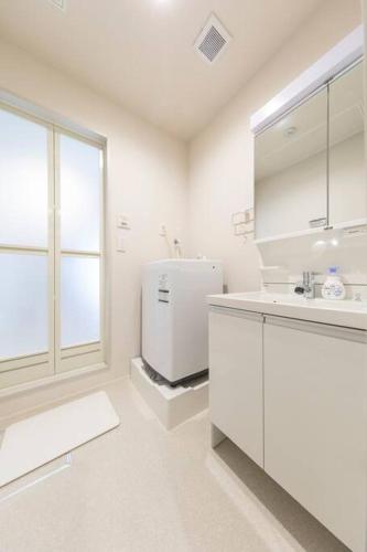 eine weiße Küche mit Spüle und Kühlschrank in der Unterkunft Logement Aile 101 in Takasaki