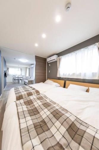ein Schlafzimmer mit zwei Betten und ein Esszimmer in der Unterkunft Logement Aile 101 in Takasaki