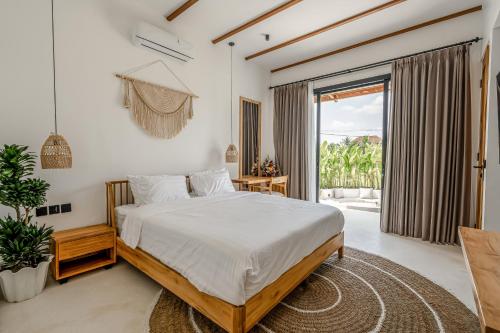a bedroom with a bed and a large window at Berapi Villa by EVDEkimi - Elegant 3BR Ubud Home with Pool & Kitchen near Central Ubud in Ubud