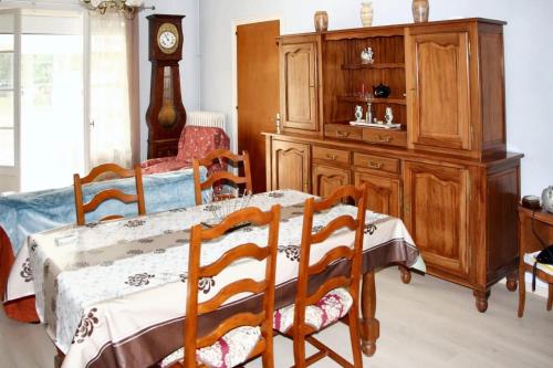 a dining room with a table and a wooden cabinet at Maison de 3 chambres avec jardin amenage a Montbron in Montbron