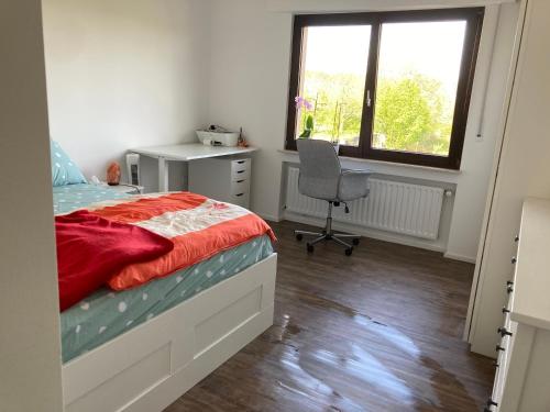 a bedroom with a bed and a desk and a chair at Nice Cozy Appartment Remich in Remich