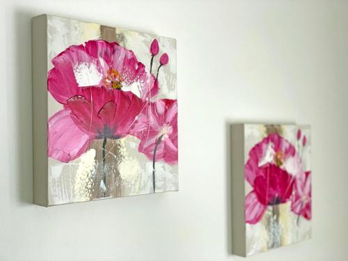 two pictures of pink flowers hanging on a wall at Sunrise Metamorfosi in Metamorfosi