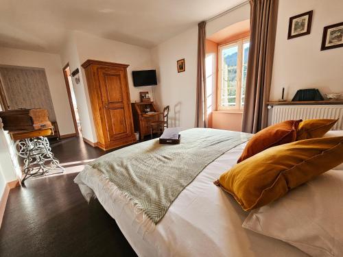 a bedroom with a large bed with a book on it at Auberge de Chanteuges in Chanteuges
