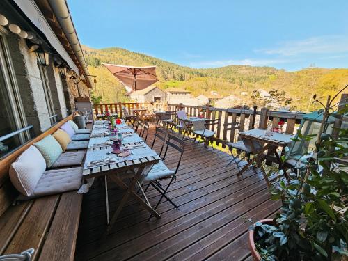 a wooden deck with tables and chairs on a balcony at Auberge de Chanteuges in Chanteuges