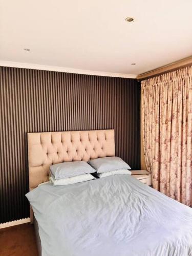 a bedroom with a large bed with two pillows at Family Home, Hillcrest in Gillitts