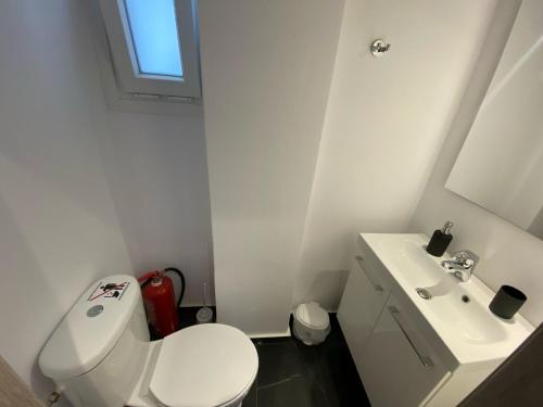 a white bathroom with a toilet and a sink at sun kiss houses in Áyios Spirídhon