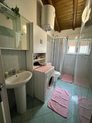 y baño con lavabo y lavadora. en Mimì e Cocò shabby house en Catania