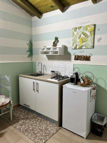 a kitchen with a sink and a stove at Mimì e Cocò shabby house in Catania