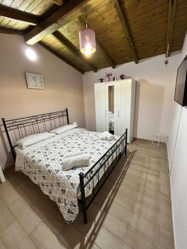 a bedroom with a large bed in a room with wooden ceilings at Mimì e Cocò shabby house in Catania