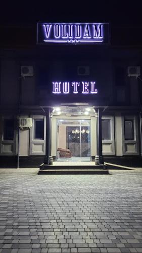 a sign on the front of a building with a sign at Volidam Hotel in Karmana