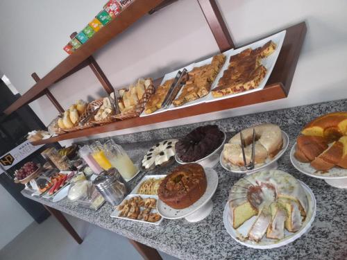 a table with a bunch of different types of pastries at Hotel Pimenta in Pimenta Bueno