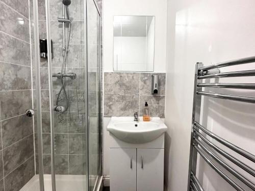 a white bathroom with a shower and a sink at Liverpool City Centre - Spacious Duplex - 6 Bedrooms - Sleeps 14 People in Liverpool