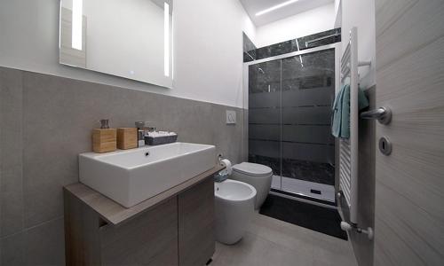 a bathroom with a white sink and a toilet at Triumvirato Rooms in Bologna