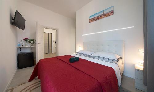 a bedroom with a large bed with a red blanket at Triumvirato Rooms in Bologna