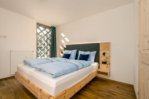 a bedroom with a large bed with blue pillows at Untermoarhof Albeins in Bressanone