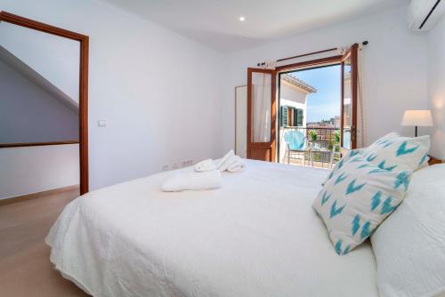 ポリェンサにあるTownhouse Lleo 72 By homevillas360の白いベッド(青い枕付)が備わるベッドルームです。