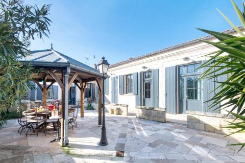 a patio with a table and a gazebo at La maison de Joséphine - Demeure familiale - 4* in Île dʼAix