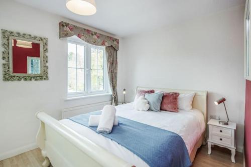a bedroom with a white bed with a blue blanket at Detached Luxury Stylish House - Staycation - Hot Tub in Warfield