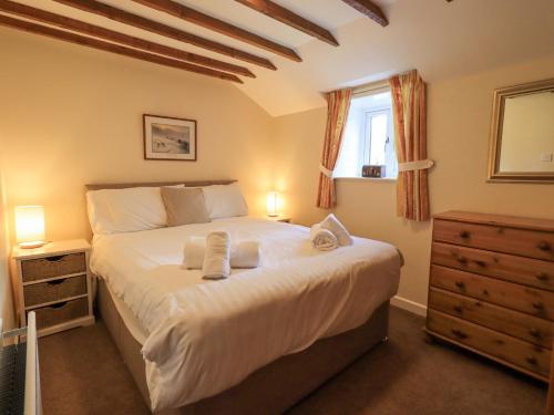 a bedroom with a large bed with towels on it at Hollens Cottage in Grasmere