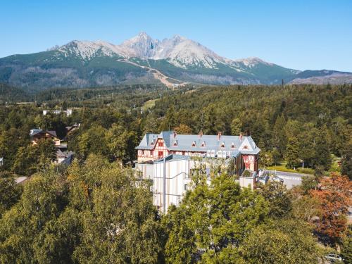 an aerial view of a house with mountains in the background at Hotel Lomnica in Tatranská Lomnica