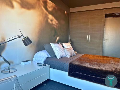 1 dormitorio con 1 cama y escritorio con lámpara en Dos Torres Silver, en Zaragoza