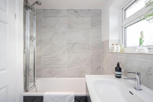 a bathroom with a white tub and a sink at Detached Luxury Stylish House - Staycation - Hot Tub in Warfield