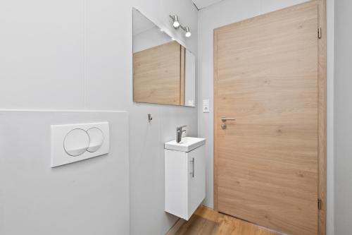 uma casa de banho com um lavatório e uma porta de madeira em Rauðafell apartment em Hvolsvöllur