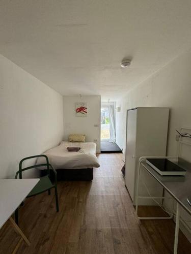 a small room with a bed and a refrigerator at Studio flat, parking, Filton in Bristol