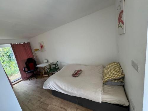 a small bedroom with a bed and a table at Studio flat, parking, Filton in Bristol