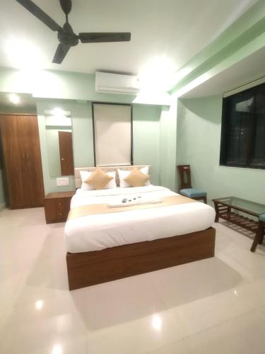 a bedroom with a large bed and a ceiling fan at Everest Stays Rooms and Dormitory in Mumbai