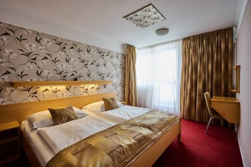 ChoceradyにあるHotel Akademieのベッドと机が置かれた寝室