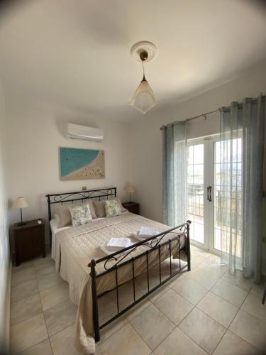 una camera con un letto e una grande finestra di Villa AnnaMaria a Skala di Cefalonia
