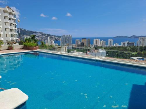 a large blue swimming pool on top of a building at Departamento con vista espectacular Anahuac in Acapulco