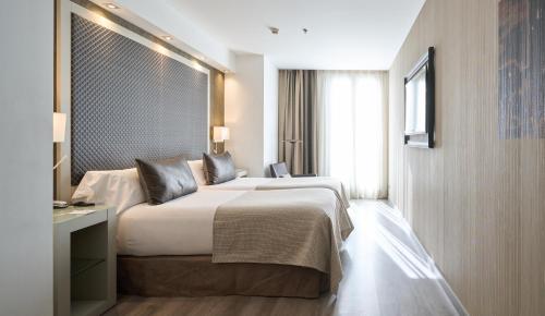 ein Hotelzimmer mit einem großen Bett und einem Fenster in der Unterkunft Catalonia Square 4* Sup in Barcelona